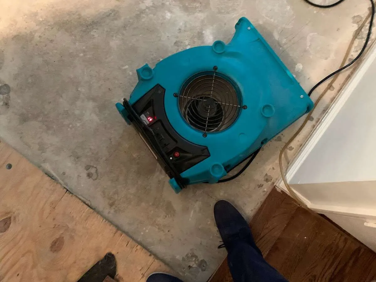 Air mover drying subfloor during Commercial Water Damage Restoration in Durant